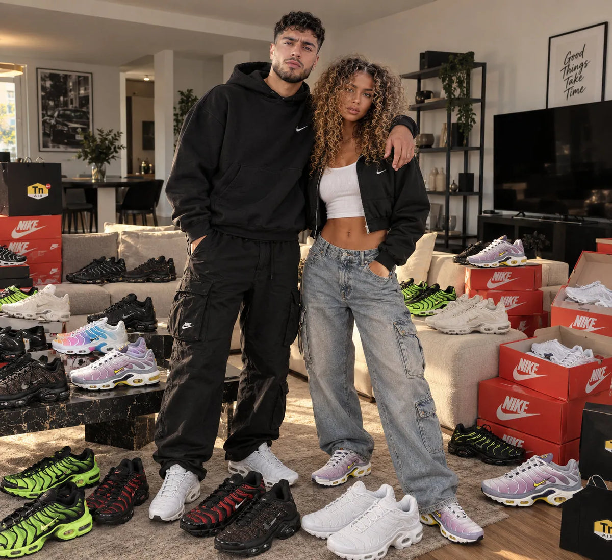 Couple portant des sneakers Nike Air Max Plus TN entourés de boîtes Nike